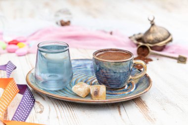 Porselen fincanda geleneksel Türk kahvesi, bir bardak su ve Türk lezzeti, kahve çekirdekli renkli badem şekerleri. Bir ziyafet (ziyafet) klasiği, Ramazan ziyafeti servis sunumu.