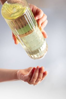 Küçük kız ellerini parfümle dezenfekte ediyor. Dezenfeksiyon ve elinizdeki virüsleri öldürmek için 80 derecelik alkol içeren Türk limon kolonyası.