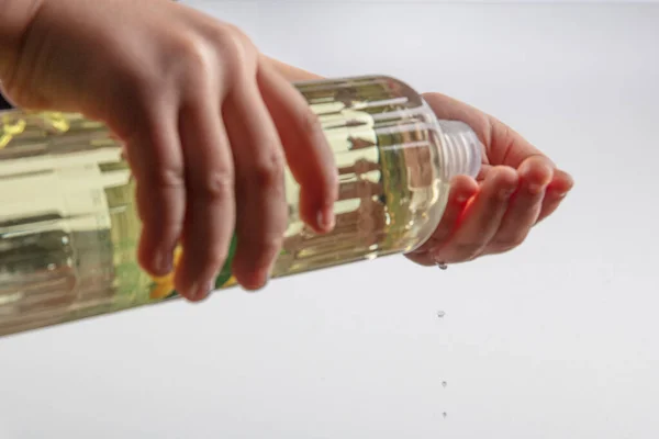 Little girl disinfecting hands with cologne. Turkish Lemon cologne with 80 degree alcohol for disinfection and killing the viruses on your hands.