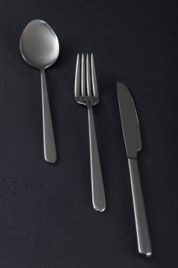 Boş tabak, çatal, bıçak, kaşık, çatal bıçak seti siyah ahşap arka plan, üst manzara.