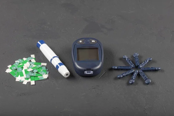 Glucometer (Sugar measuring device) and syringe for insulin, monitoring of diabetes mellitus isolated on black background.