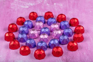 Folyodaki çikolatalar. Seni neşelendirmek için tatlılar. Lezzetli tatlılar leylak arka planda harika bir bayram hediyesidir. Kurban Bayramı (Ramazan Bayramı) veya Sevgililer Günü konsepti.