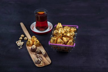 Fındıklı çikolata, fındıklı çikolata, mor ahşap arka planda altın folyoya sarılır. Kurban Bayramı (Ramazan Bayramı) kavramı.