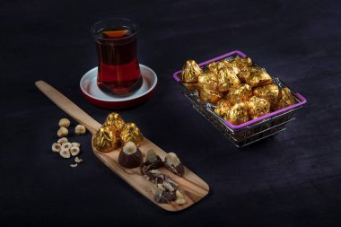 Fındıklı çikolata, fındıklı çikolata, mor ahşap arka planda altın folyoya sarılır. Kurban Bayramı (Ramazan Bayramı) kavramı.