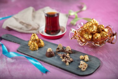 Parlak ambalajda çikolata şekeri. Ahşap arka planda lezzetli çikolata şekerlemeleri. Ramazan Bayramı (Ramazan Bayramı) Konsepti.