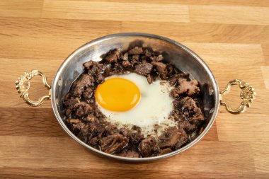 Türk usulü kızarmış et (kavurma). Kavurma ile çırpılmış Türk yumurtası. Ahşap masada kızartılıyor. Kurban Bayramı kavramı.