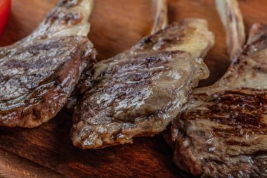 Tahta tabakta et: ahşap üzerinde pirzola, domates, biber ve ahşap masada kuru baharat.