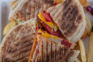 Patates kızartmalı hamburger ve ahşap arka planda sebze salatası.