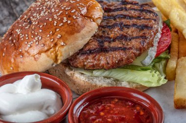 Kızarmış domuz burger, patates kızartması ve sos, yakın çekim.