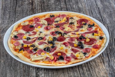 Tahtada taze dilimlenmiş karışık pizza.