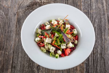 Tavuklu salata, domates ve beyaz tabakta roka. en üstteki görünüm.