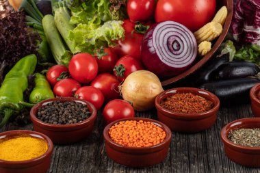 Ahşap arka planda çeşitli baharatlı sebzeler ve otlar.