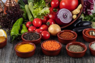 Ahşap arka planda çeşitli baharatlı sebzeler ve otlar.