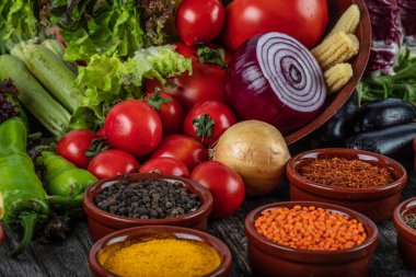 Ahşap arka planda çeşitli baharatlı sebzeler ve otlar.