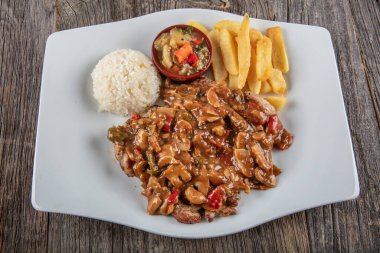 Patates kızartması, sebzeli ragout ve ahşap arka planda et.