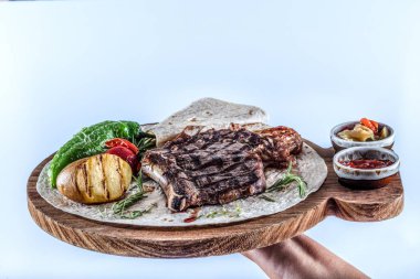 Tahtada sebzeli ve baharatlı ızgara biftek.