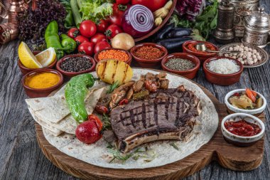 Sebzeli ızgara biftek ve ahşap tahtada sos.