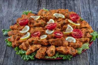 Domates ve limonla süslenmiş ızgara tavuk.