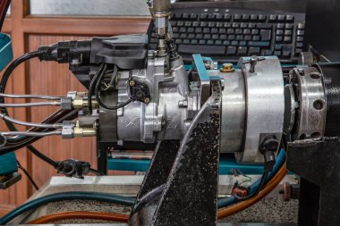 Profesyonel mekanikler atölyesinde dizel enjektörü, onarım ve tanı ekipmanlarını test ediyor. Dizel motorlar için enjektörleri test edin, kapatın.
