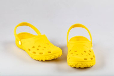 yellow rubber sandals on white background