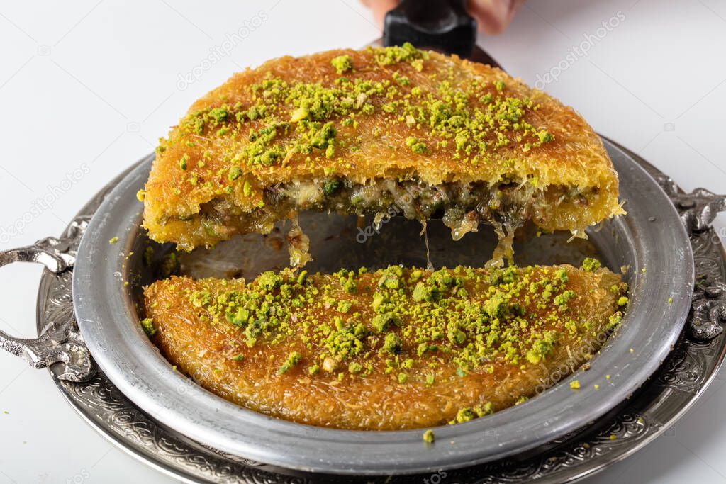 Traditional Turkish Dessert Kunefe (kadayif). Kunefe with cheese. Turkish dessert kunefe, kunafa, kadayif with pistachio powder.