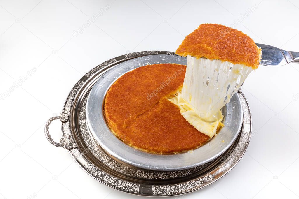 Turkish dessert kunefe, kunafa, kadayif with pistachio powder and cheese, served hot, very sweet. Turkish traditional dessert.