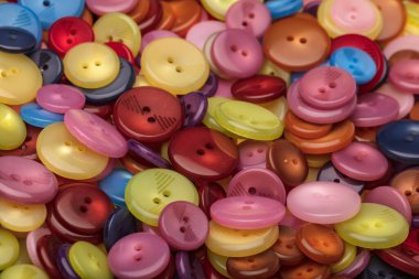 Çeşitli şekil ve boyutlarda bir sürü renkli düğme. Plastik düğmeler, renkli düğmeler arka plan, düğmeler kapalı, düğmeler arka plan. 