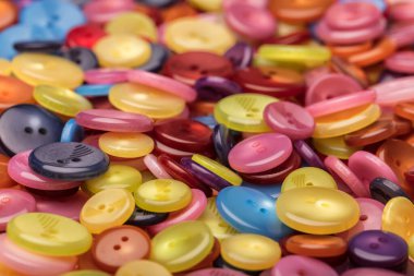 Çeşitli şekil ve boyutlarda bir sürü renkli düğme. Plastik düğmeler, renkli düğmeler arka plan, düğmeler kapalı, düğmeler arka plan. 