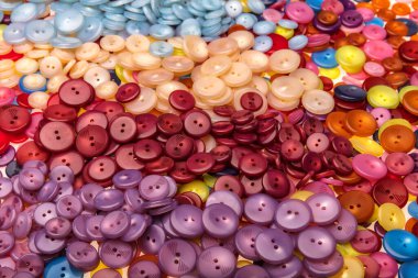 Çeşitli şekil ve boyutlarda bir sürü renkli düğme. Plastik düğmeler, renkli düğmeler arka plan, düğmeler kapalı, düğmeler arka plan. 