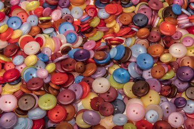 Çeşitli şekil ve boyutlarda bir sürü renkli düğme. Plastik düğmeler, renkli düğmeler arka plan, düğmeler kapalı, düğmeler arka plan. 