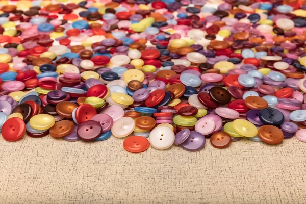 Many colorful garment buttons in various shapes and sizes. Plastic buttons, Colorful buttons background, Buttons close up, Buttons background.