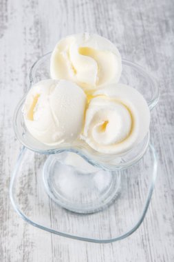 Tahta arka planda bir kase vanilyalı dondurma. Yukarıdan bakıldığında