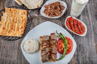 grilled meat with vegetables and sauce on wooden background
