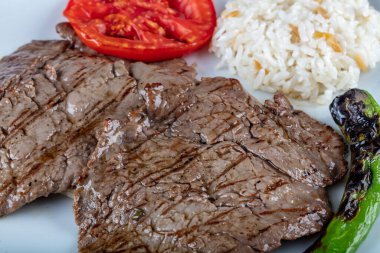 Orta pişmiş sığır filetosu ızgara, ahşap arka planda sebzelerle arka plan oluşturuldu..