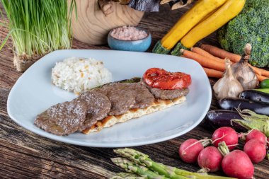 Orta pişmiş Türk köfteleri (Türk Gıda Kofte veya Kofta), ahşap zemin üzerinde sebzelerle arka plan oluşturdu. Türkçe adı: Sivas Kofte.