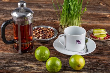 Bir fincan limonlu çay ve ahşap zemin üzerinde nane.