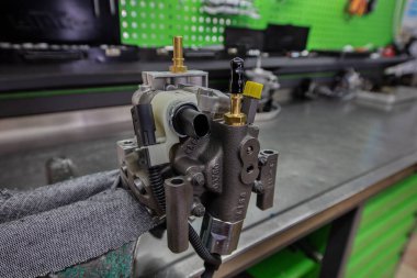 Yakıt pompası tamir ediliyor, kapatın. Profesyonel mekanik, atölyesinde dizel enjektörü, onarım ve tanı ekipmanlarını test ediyor.