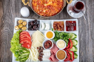 Geleneksel Türk kahvaltı tabağı gri ahşap masa, üst manzara. Parlak sabahlarda sağlıklı Türk kahvaltısı; metin için boşluk kopyala.