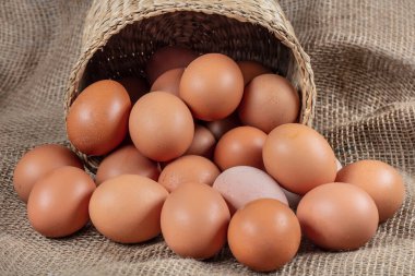 Yumurtalar. Tahta bir arka planda saman sepetinde birkaç taze tavuk yumurtası. Sağlıklı yeme kavramı.