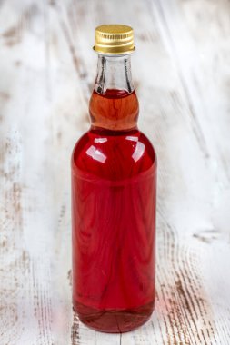 Ahşap zemin üzerinde kırmızı şarap olan cam şişe.