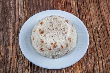 Ahşap arka planda bir kasede pilav pişirdim.