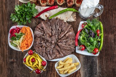 Sebzeli ızgara biftek ve ahşap masada sos.