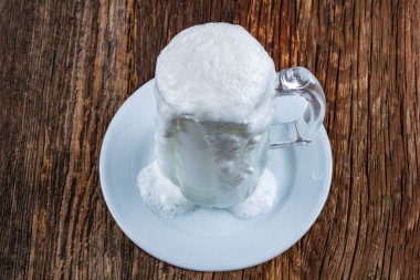 Tahta arka planda bir bardak sütle birlikte beyaz dondurma.