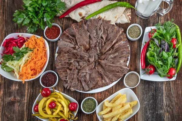 Sebzeli ızgara biftek ve ahşap masada sos.