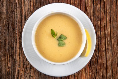 Tahta arka planda tavuk ve sebzeli kremalı çorba.