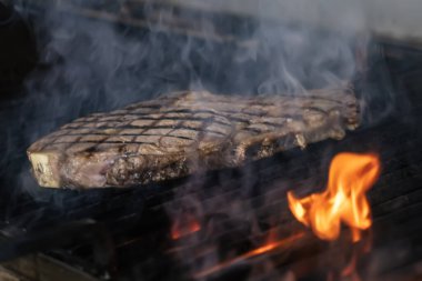 Izgarada alevli biftek var. Izgara ızgara ızgara ve seçici odaklı çekim.