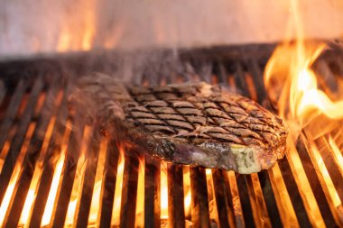 Izgarada alevli biftek var. Izgara ızgara ızgara ve seçici odaklı çekim.