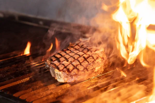 火でグリル上の牛ステーキ グリルステーキ上の炎のグリルと選択的な焦点で撮影 — ストック写真