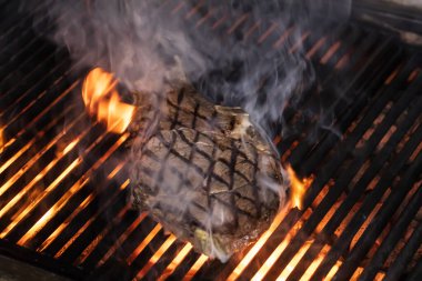 Izgarada alevli biftek var. Biftek bifteği (Dallas bifteği) ızgarada alevlerle.