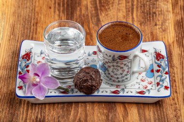 Geleneksel Türk Kahve fincanı kavramı ve tahta arka planda çikolatalar..